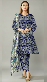Woman wearing a blue floral outfit with a matching dupatta in an indoor setting.